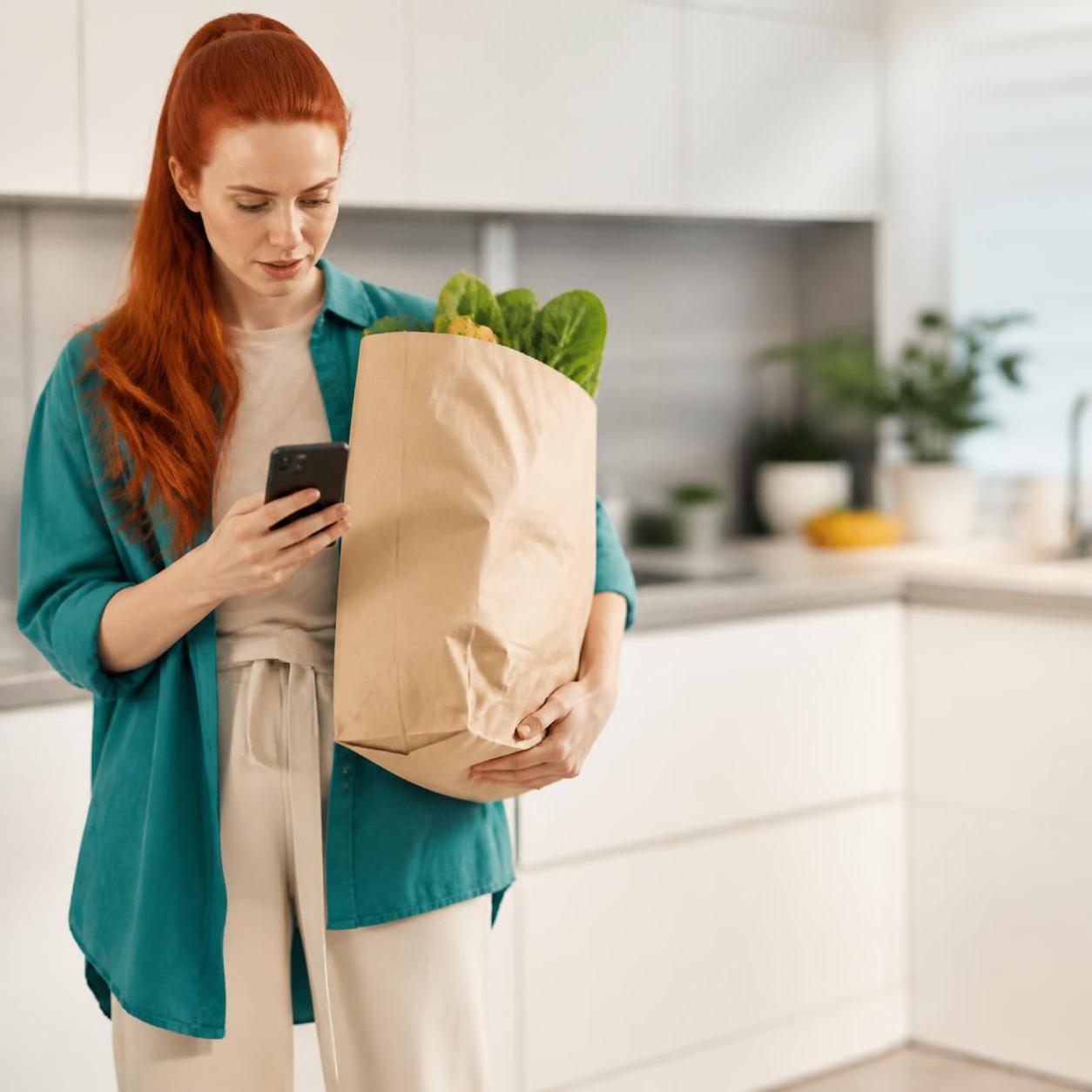 Woman Checking Phone with Groceries
